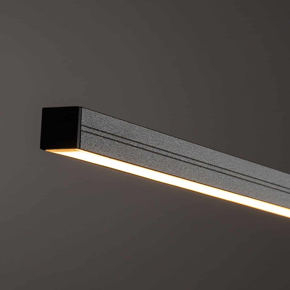 Lampa wisząca Bar L150 o prostokątnym kształcie, wykonana z metalu w kolorze oliwkowym, z wbudowanym źródłem LED 32W, emitującym ciepłe światło (3000K). Ujęcie zbliżeniowe ukazuje detal konstrukcji oraz krawędzie lampy.