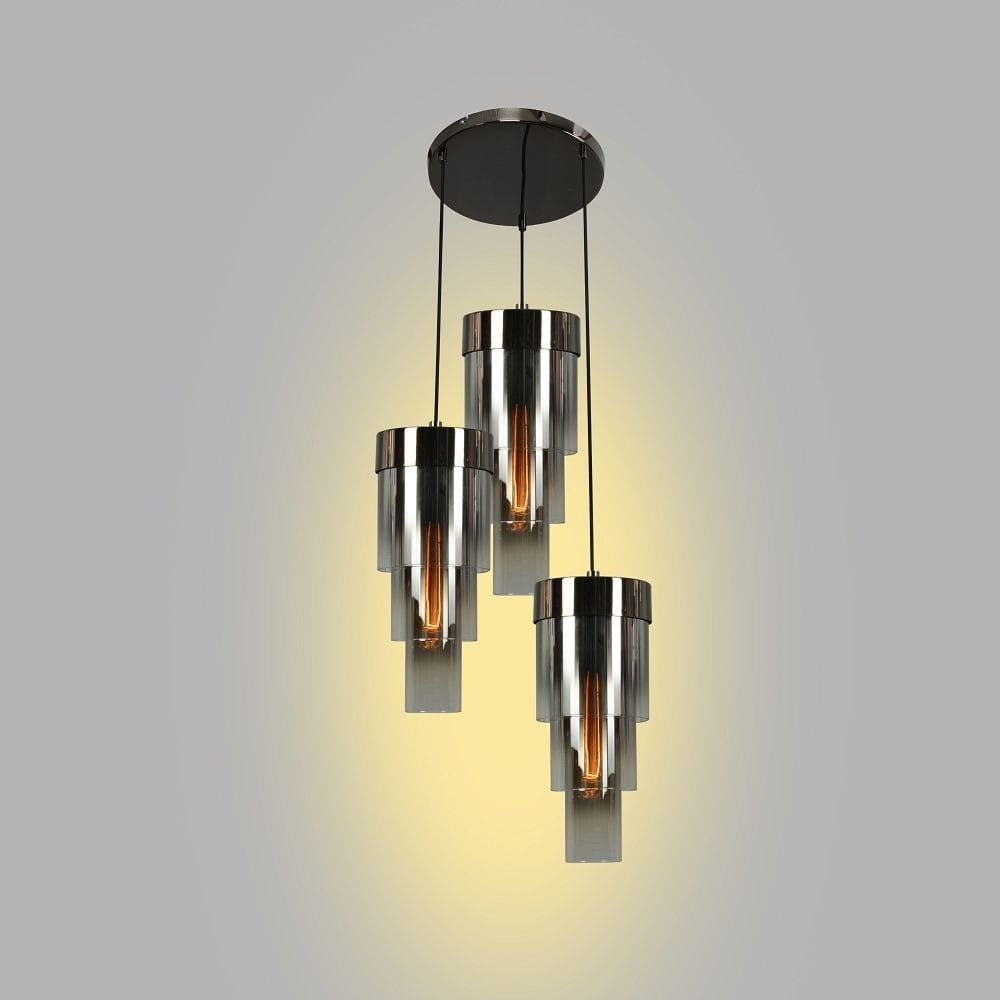 Lampa wisząca Grans 3xE27 w kolorze czarnym i chromowanym. Składa się z trzech cylindrycznych kloszy w odcieniu srebrnym, zawieszonych na cienkich linkach, z okrągłą podstawą. Emituje ciepłe światło, idealna do nowoczesnych wnętrz.