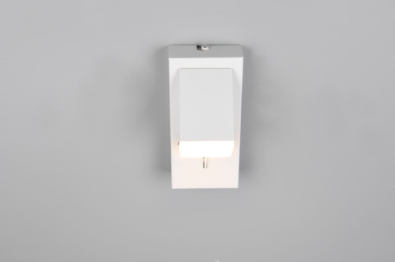 Raglan kinkiet w kolorze białym, zamontowany na ścianie, z prostokątnym korpusem i źródłem światła LED o mocy 3,8W. Kinkiet ma minimalistyczny design, emitując ciepłe światło w dół, idealny do nowoczesnych wnętrz.