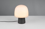 Lampa stołowa Steen z kloszem w kształcie grzyba w kolorze białym, osadzona na czarnej, matowej podstawie. Ujęcie frontalne, na jednolitym tle. Widoczny kabel zasilający. Przeznaczona do żarówki E14.
