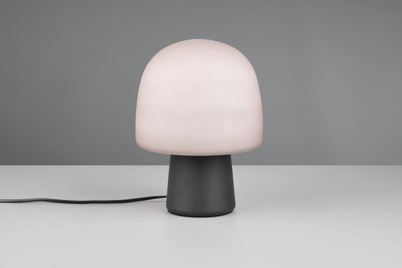 Lampa stołowa Steen w kolorze czarnym i szarym z okrągłym kloszem w odcieniu mlecznym. Produkt widoczny z przodu, na białym tle. Posiada prostą, cylindryczną podstawę oraz kabel zasilający. Idealna do nowoczesnych wnętrz.