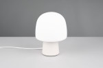 Lampa stołowa Steen w kształcie grzyba z białym kloszem i szarym podstawą. Ujęcie frontalne, produkt stoi na szarej powierzchni. Wtyczka widoczna z boku, minimalistyczny design. Idealna do nowoczesnych wnętrz.