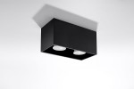 Czarna lampa sufitowa Quad Maxi, 2-punktowa, z prostokątnym korpusem. Ujęcie z dołu, pokazujące dwa okrągłe klosze. Produkt zamontowany na białym tle, bez dodatkowych dekoracji. Świecące źródła światła widoczne wewnątrz lampy.
