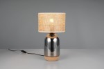 Lampa stołowa Tara z podstawą w kolorze chromu i naturalnego korka. Okrągły abażur w jasnym odcieniu z teksturowanym wykończeniem. Produkt ustawiony na stole, z widocznym kablem zasilającym.