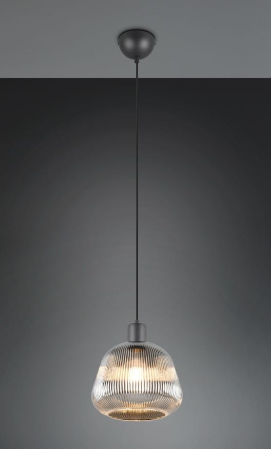 Lampa wisząca Tarifa z kloszem w czarnym kolorze, wykonana z przezroczystego materiału o żłobionej fakturze. Zawieszona na cienkim przewodzie, z okrągłym mocowaniem sufitowym. Wymaga jednej żarówki E27. Tło w odcieniu szarości.
