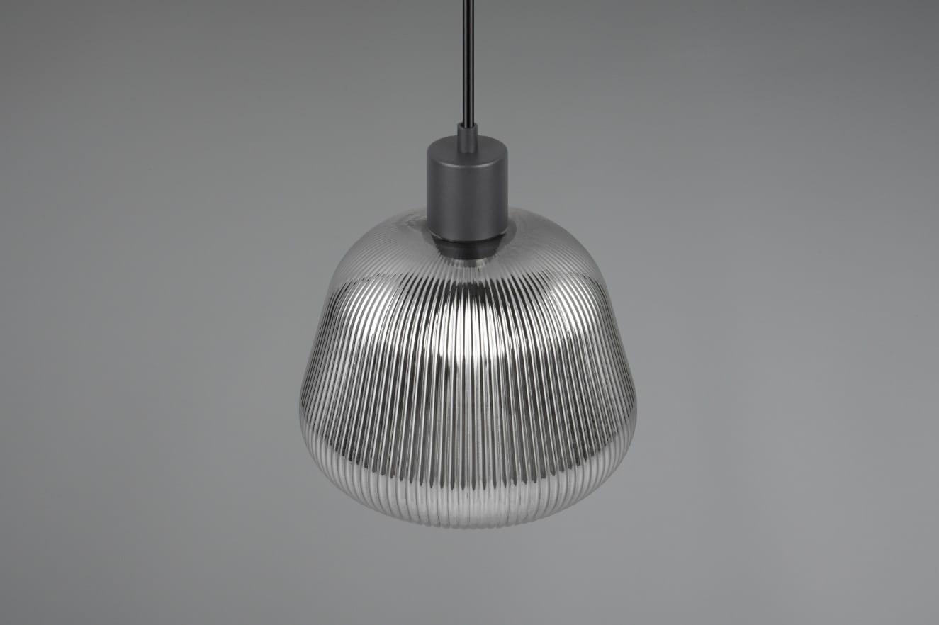 Czarna lampa wisząca Tarifa z jednym gniazdem E27, o opływowym kształcie z wyraźnym, teksturowanym wzorem. Zawieszona na cienkim przewodzie, prezentuje się w zbliżeniu, ukazując detale konstrukcji. Tło szare, minimalistyczne.