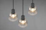 Lampa wisząca Tarifa 3xE27 w kolorze czarnym z przezroczystymi, prążkowanymi kloszami. Zawieszona pod sufitem, na trzech czarnych linkach. Klosze emitują ciepłe światło, tworząc przytulną atmosferę.
