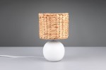 Lampa stołowa Vina z białą podstawą w kształcie kuli oraz kloszem z plecionego naturalnego materiału. Ujęcie frontalne, lampa stoi na gładkiej powierzchni, kabel zasilający widoczny z boku.