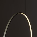 Lampa wisząca Circolo D60 w kolorze oliwkowym, z metalowym okręgiem. Źródło światła LED o mocy 21W i temperaturze barwowej 3000K. Produkt zawieszony na czarnych linkach, z widocznym delikatnym podświetleniem wewnętrznym.