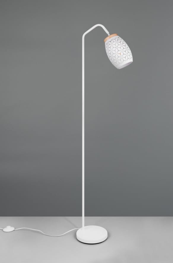 Biała lampa podłogowa Bidar z kloszem w geometryczny wzór, z metalowym stelażem. Ujęcie frontalne, stojąca na okrągłej podstawie, z przewodem zasilającym widocznym na podłodze. Klosz z drewnianym akcentem na górze.