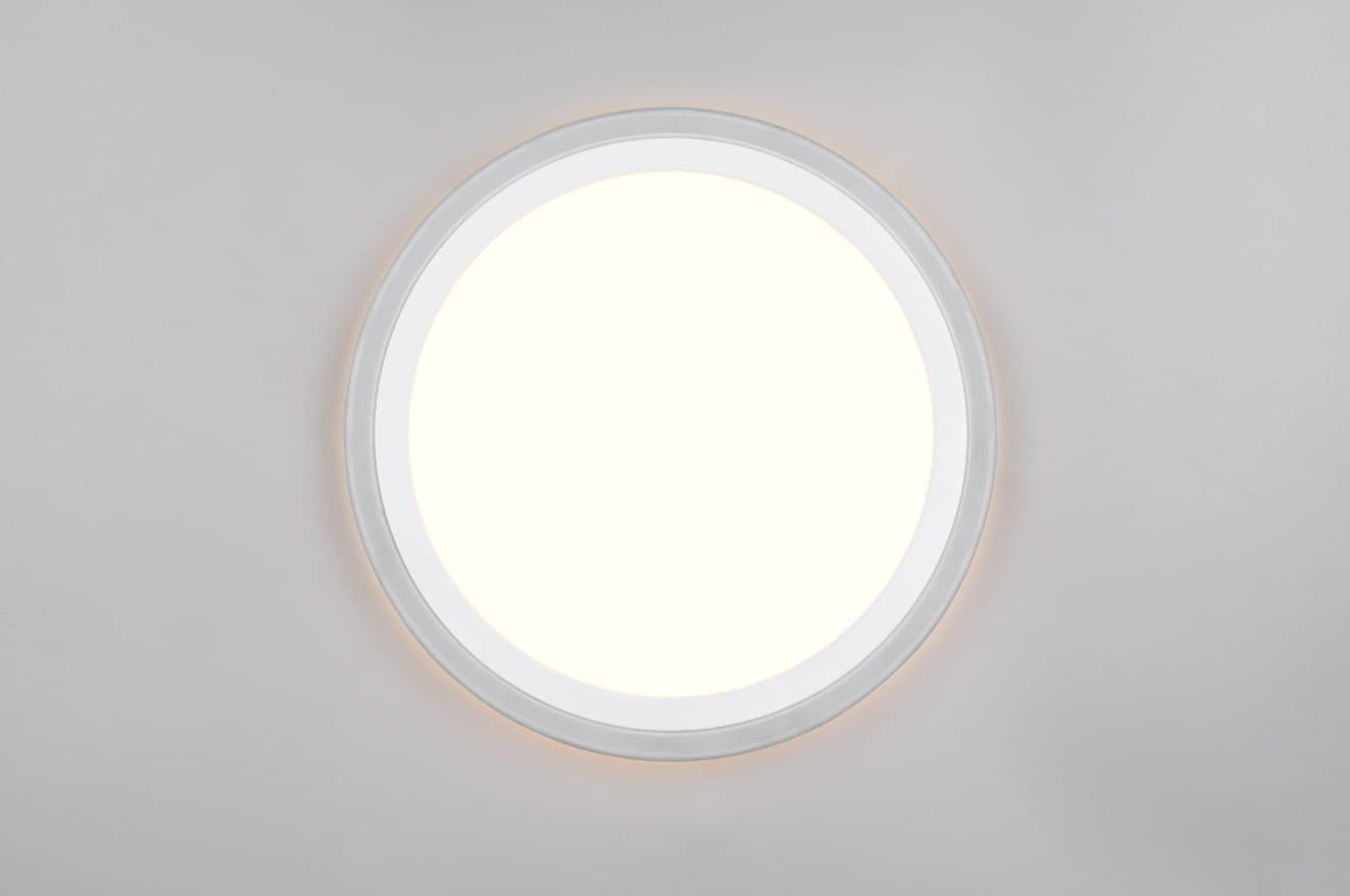 Plafon Cora 2xLED o mocy 12,2 W w kolorze białym, okrągły kształt, umieszczony na jasnym tle. Jasne, równomierne oświetlenie z delikatnym podświetleniem, stonowany design bez widocznych napisów i logo.