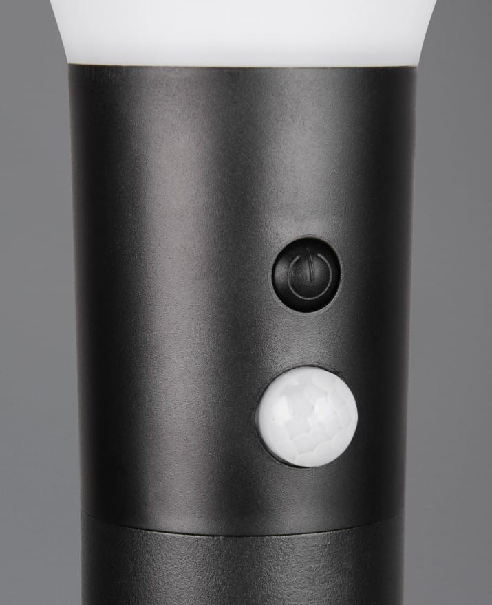 Czarna lampa stojąca ogrodowa Gorda H50 z czujnikiem ruchu, wykonana z materiału odpornego na warunki atmosferyczne. Widoczne przyciski do włączania oraz czujnik ruchu, umieszczone na cylindrycznym korpusie.