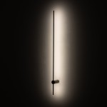 Kinkiet Saber 120 w kolorze oliwkowym, z jednym źródłem LED o mocy 16W i temperaturze barwowej 4000K. Prosta, pozioma forma w ciemnym kolorze z okrągłym mocowaniem, emitująca ciepłe światło na tle jasnej ściany.