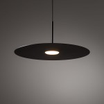 Czarna lampa wisząca Simone z jednym źródłem światła GX53. Okrągła, matowa czasza z centralnym otworem na żarówkę, zawieszona na cienkim przewodzie. Prosta forma, idealna do nowoczesnych wnętrz.