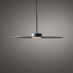 Lampa wisząca Simone w kolorze niebieskim z pojedynczą oprawą GX53. Posiada okrągły, płaski klosz zawieszony na cienkim przewodzie. Umieszczona centralnie, emituje światło w dół. Tło w odcieniu szarym, minimalistyczne.
