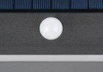 Czarny kinkiet zewnętrzny Ramos z solarnym zasilaniem, czujnikiem ruchu i diodą LED 8W. Widoczny biały element czujnika ruchu na tle matowej powierzchni. Produkt montowany na ścianie, przeznaczony do użytku na zewnątrz, klasyfikacja IP44.