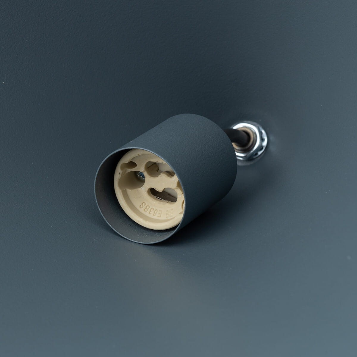 Niebeśka lampa wisząca Zenith S z oprawką GU10. Widok z bliska na element montażowy, z teksturą matową i prostej formie. Widzoczna oprawka w kolorze szarym z jasnym wnętrzem.