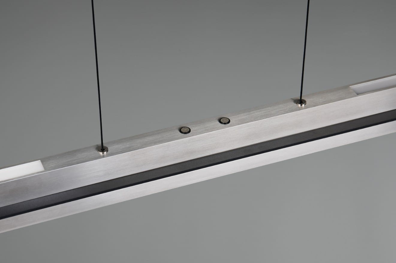 Lampa wisząca Emerson w kolorze niklu, z jednym źródłem światła LED o mocy 22W. Prostokątna konstrukcja z metalowymi detalami, zawieszona na cienkich linkach. Widoczny przycisk włączania oraz elementy mocujące. Tło szare, minimalistyczne.