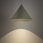 Lampa wisząca Zenith L w kolorze szałwii, w kształcie stożka, zawieszona na cienkim przewodzie. Emituje ciepłe światło, które tworzy delikatny cień na ścianie. Wykończenie matowe, minimalistyczny design, idealna do nowoczesnych wnętrz.