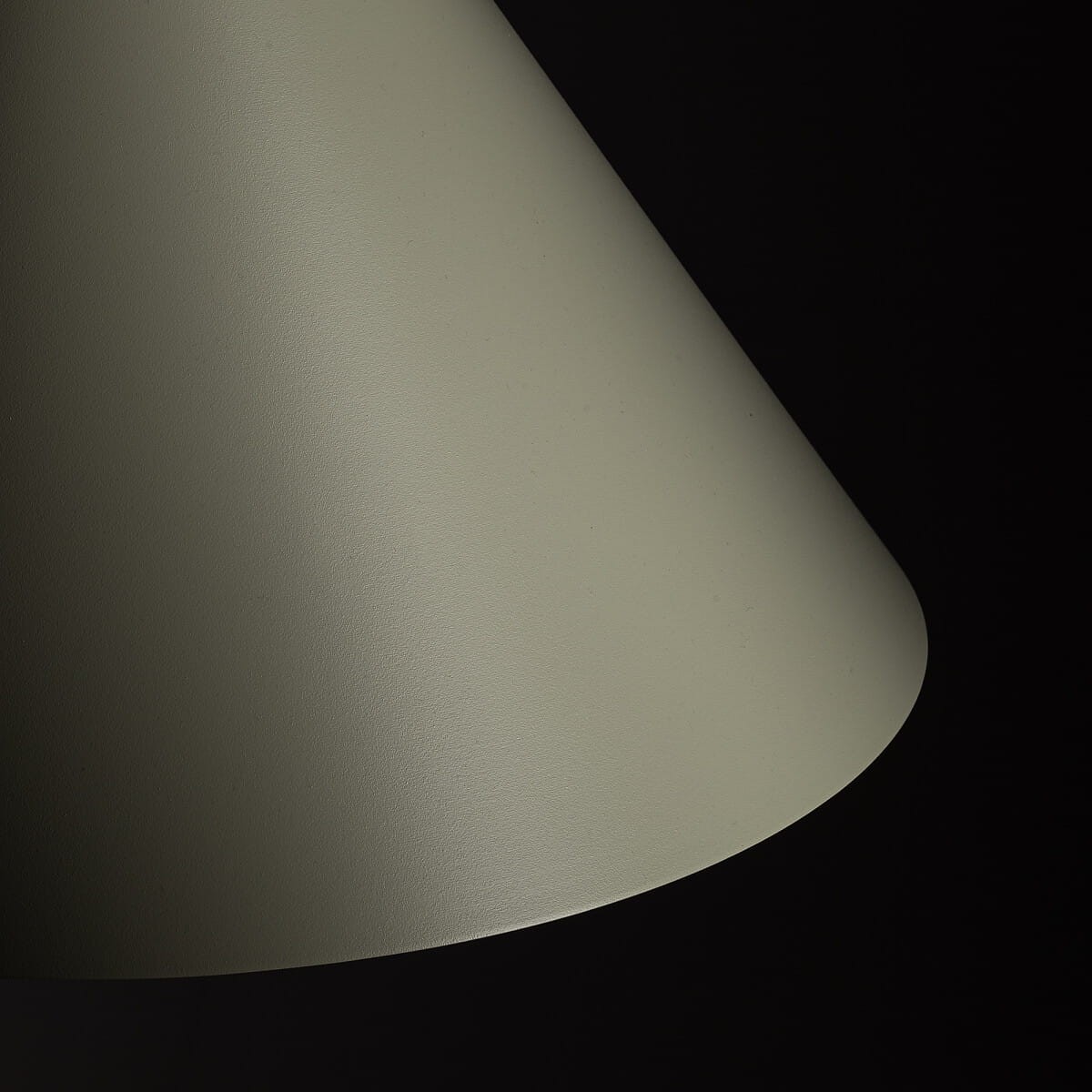Lampa wisząca Zenith L w kolorze szałwii, o kształcie stożkowym z matową powierzchnią. Ujęcie z boku ukazuje delikatne zaokrąglenia krawędzi. Widoczny gwint na żarówkę typu GU10. Tło ciemne, co podkreśla kolor lampy.