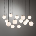 Lampa wisząca Snowball XIV z 14 kulistymi kloszami w białym kolorze, zawieszonymi na czarnych linkach. Klosze o matowej powierzchni różnej wielkości, wiszące w różnych wysokościach na prostym tle.