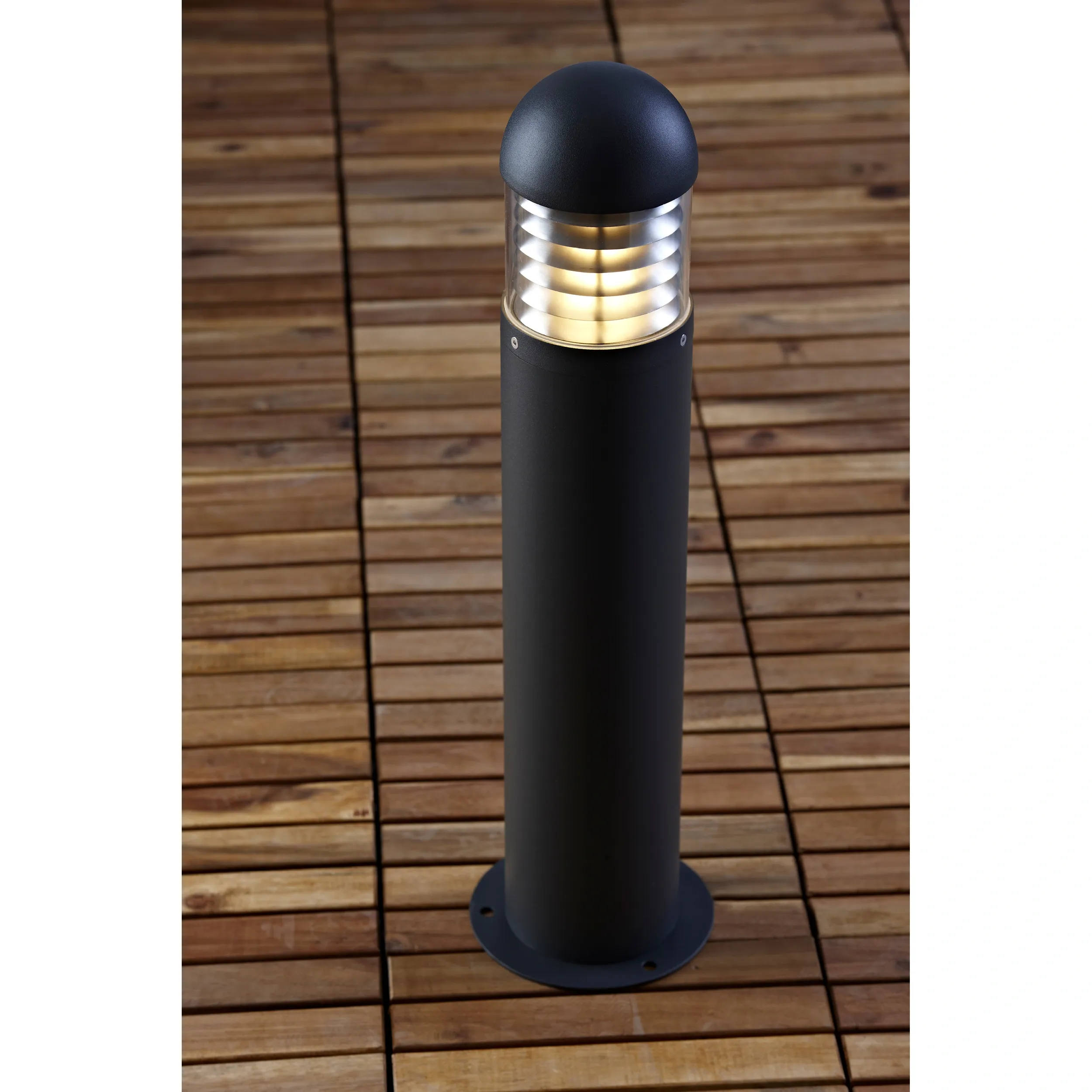 Lampa ogrodowa stojąca Kurt H60 w ciemnoszarym kolorze, z metalowym korpusem i okrągłym kloszem. Ujęcie z góry, ukazujące strukturę klosza z żłobieniami. Produkt umieszczony na drewnianym podłożu.