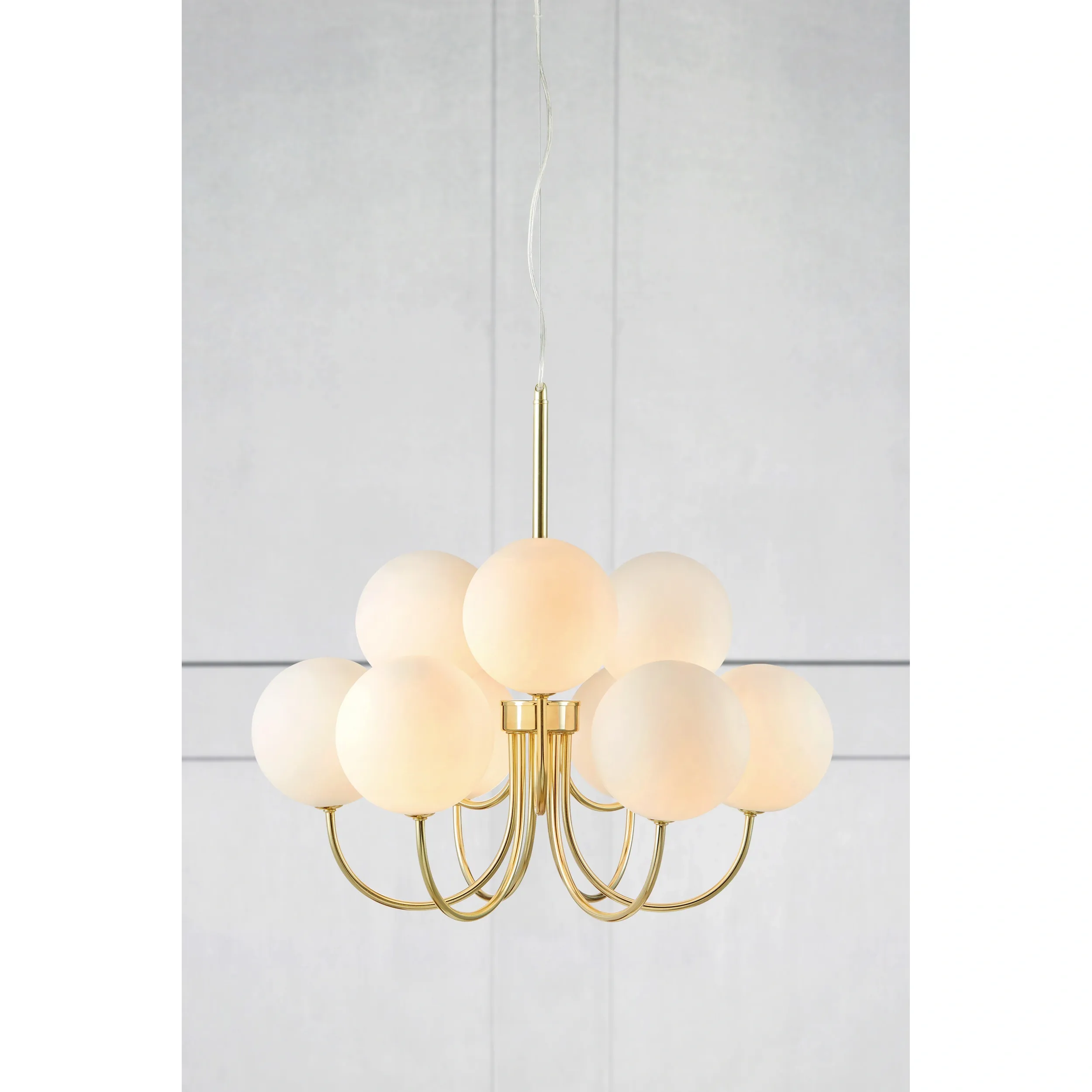 Lampa wisząca Bianco 9-punktowa w kolorze złotym i białym. Posiada dziewięć mlecznych kul z matowego szkła, zamocowanych na złotej podstawie z metalowymi ramionami. Zawieszona na cienkim przewodzie, prezentuje nowoczesny design.