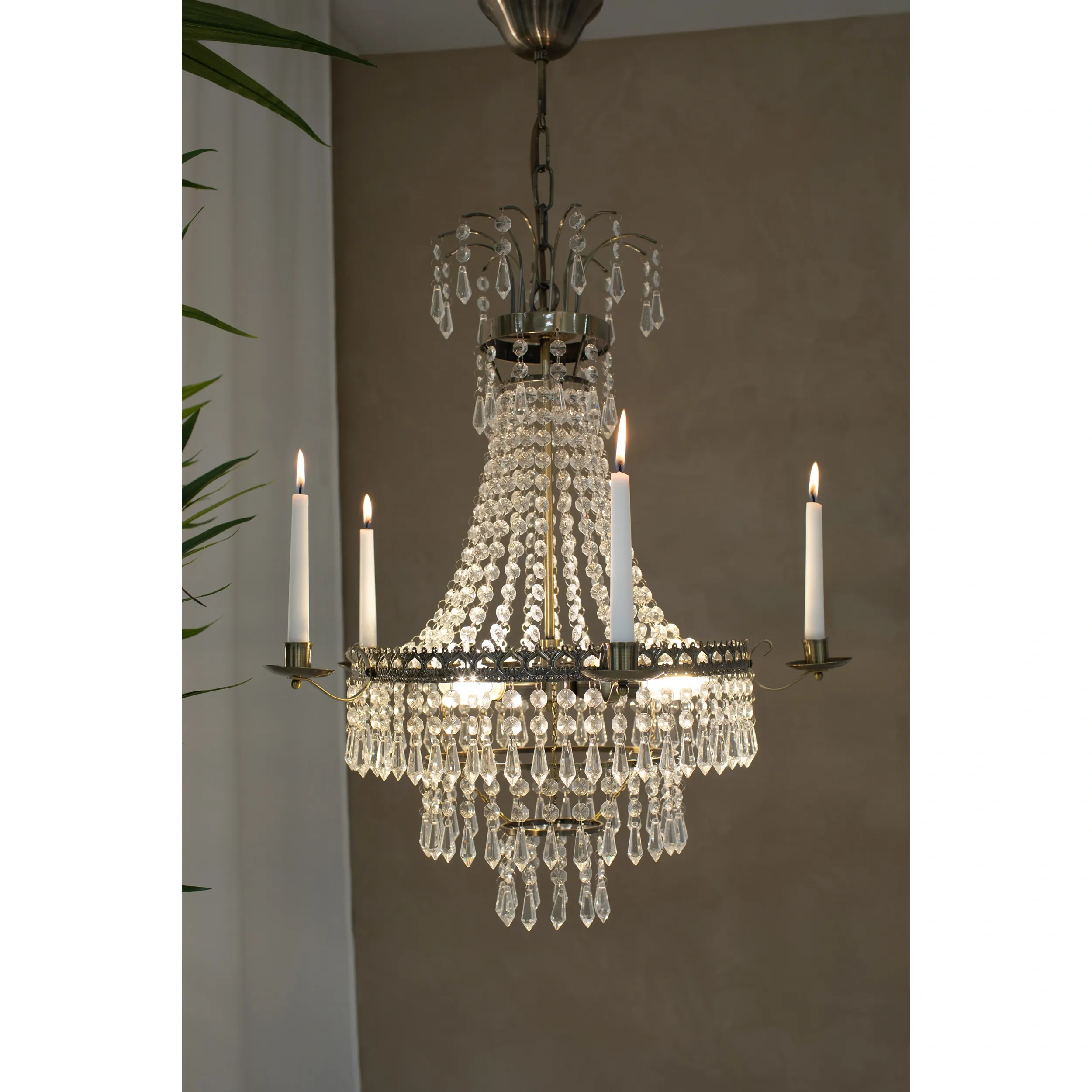 Lampa wisząca Marielund 3-punktowa w stylu antycznym, z kryształowymi zdobieniami i trzema świecznikami z białymi świecami. Ujęcie frontalne, lampa zawieszona, w tle neutralna ściana. Elegancka dekoracja do wnętrz.