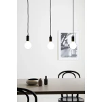 Lampa wisząca Sky 3-punktowa w kolorze czarnym, zawieszona na długich kablach. Trzy okrągłe żarówki w metalowych oprawach, na tle jasnej ściany. W dolnej części widoczny stół z akcesoriami, w tym ceramiczną misą i dwoma wazonami.