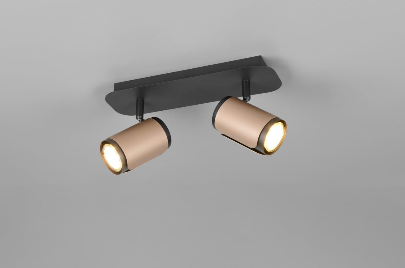 Lampa sufitowa Gillan z dwoma reflektorami w kolorze czarnym i kawowym. Ułożona poziomo na prostokątnej podstawie. Reflektory o cylindrycznym kształcie, z widocznymi żarówkami GU10, skierowane w różnych kierunkach. Tło jasnoszare.