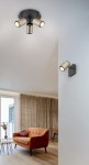 Lampa sufitowa Gillan w kolorze czarnym i kawowym, z trzema ruchomymi reflektorami GU10. Ujęcie z góry, pokazujące lampę zamontowaną na suficie w nowoczesnym wnętrzu z pomarańczową sofą i zasłonami.
