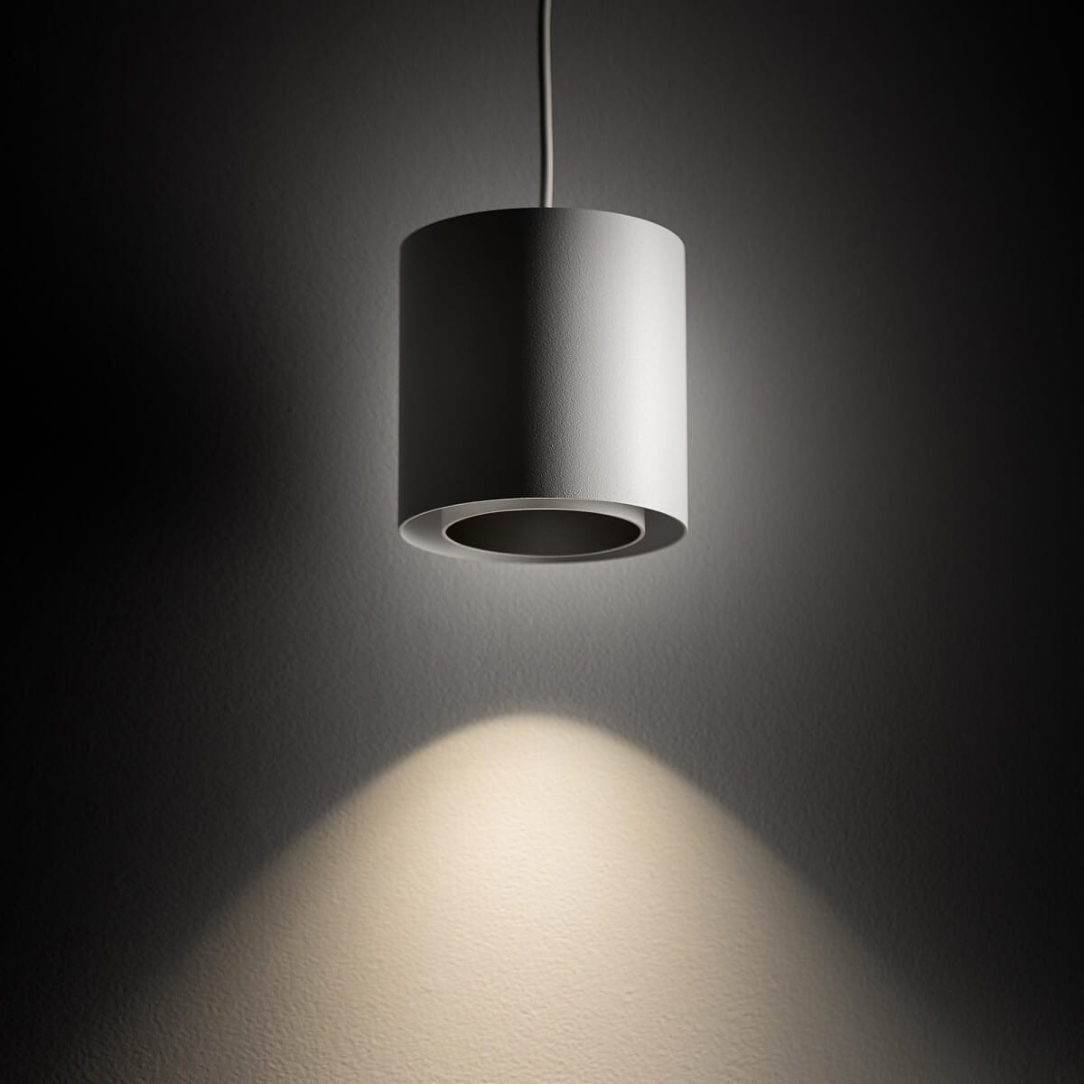 Lampa wisząca Point Duo 1xGU10 w kolorze białym z okrągłym kloszem. Wisi na cienkim przewodzie, emitując światło w dół na ciemną powierzchnię. Klosz ma matową fakturę i minimalistyczny design.