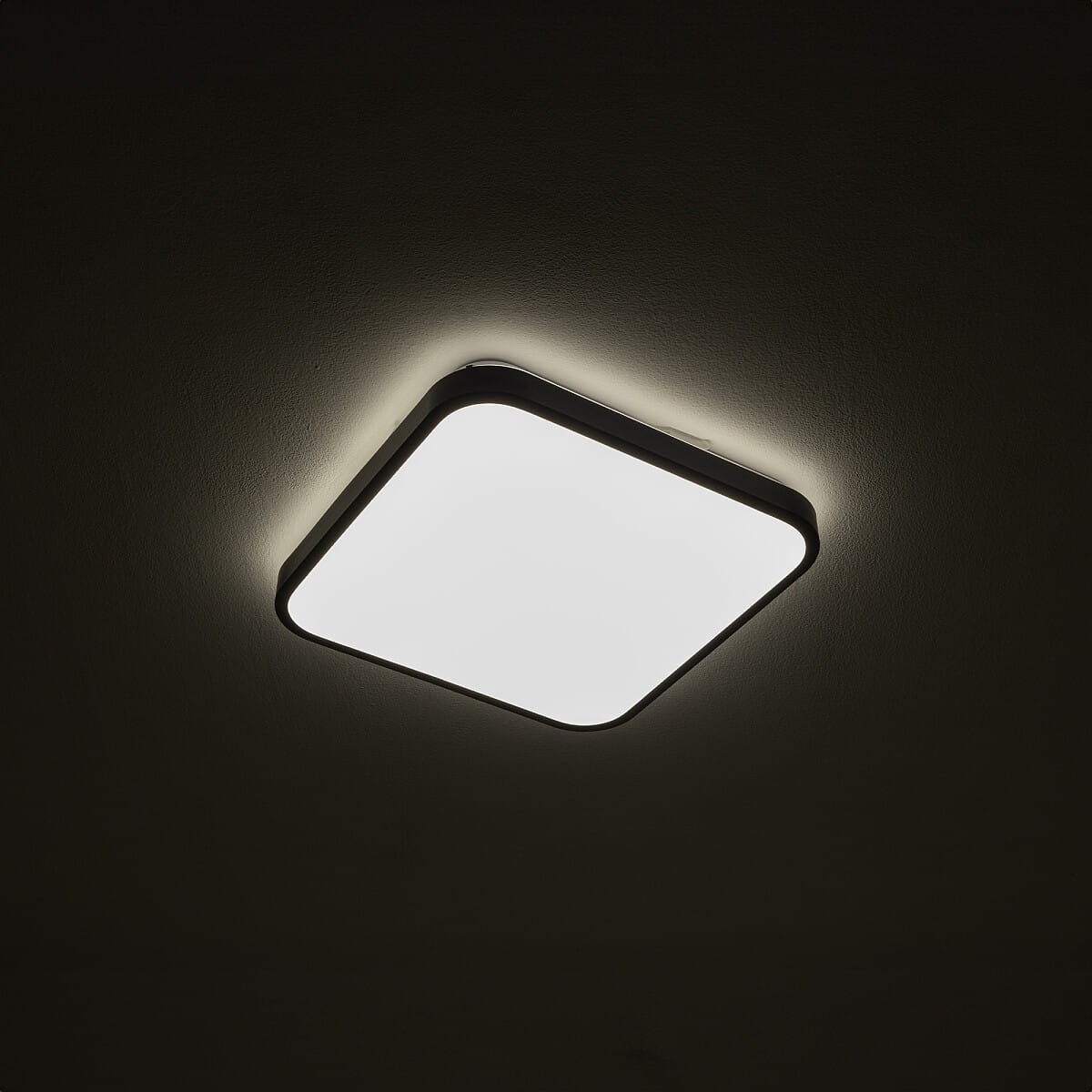 Plafon Agnes Square LED 33,5 cm, czarny, o mocy 16W i barwie światła 3000K. Kwadratowy kształt z białą, gładką powierzchnią oraz delikatnym podświetleniem wokół. Montowany na suficie, idealny do oświetlenia wnętrz.