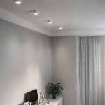 Biała lampa sufitowa tuba 1xGX53, zamontowana w grupie trzech punktów świetlnych, o okrągłym kształcie. Ujęcie z góry, na tle jasnej ściany, w nowoczesnym wnętrzu z rośliną i meblami.
