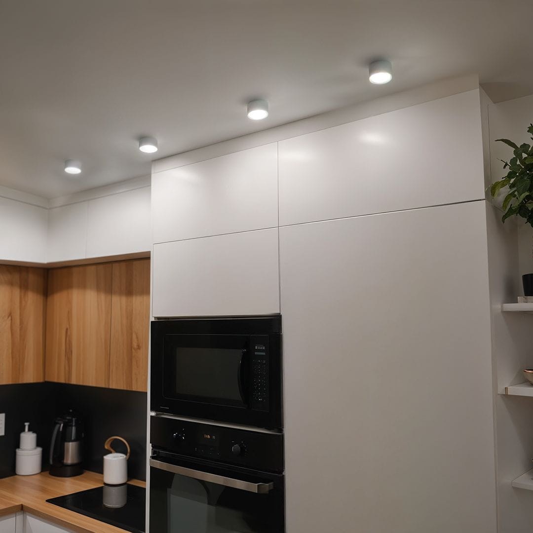 Leto lampa sufitowa tuba 1xGX53 w kolorze białym, zamontowana na gładkim suficie w kuchni. Widać trzy źródła światła, które równomiernie oświetlają przestrzeń nad nowoczesnymi meblami w odcieniach bieli i drewna.