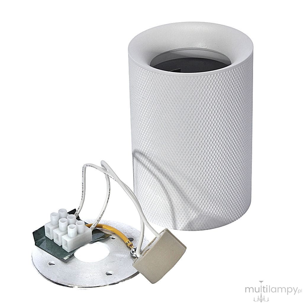 Biała lampa sufitowa w kształcie tuby, wykonana z matowego materiału, z widocznym wnętrzem dla żarówki GU10. Ujęcie pokazuje lampę leżącą obok metalowej podstawy z przewodami i złączami elektrycznymi.