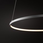 Lampa wisząca Circolo D60 w kolorze białym z okrągłym metalowym korpusem, zawieszona na cienkich żyłkach. Emituje ciepłe światło LED o mocy 21W i temperaturze 3000K, widoczna jest tylko górna część lampy. Tło ciemne, podkreślające design.