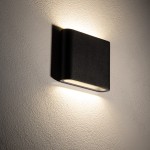 Kinkiet elewacyjny Semi S w kolorze czarnym, o prostokątnej formie, zamontowany na ścianie. Emituje ciepłe światło (3000K) z dwóch diod LED (6W). Tekstura obudowy jest matowa, a kształt minimalistyczny, co podkreśla nowoczesny design.