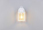 Biały kinkiet zewnętrzny Mirande z oprawą w formie lampionu, z widoczną żarówką E27. Ujęcie frontalne, produkt zamontowany na ścianie, z prostą, elegancką konstrukcją. Tło szare, co podkreśla jasność lampy.