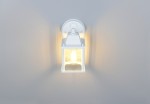Biały kinkiet zewnętrzny Mirande z jedną oprawą E27, o prostokątnym kształcie, zamontowany na ścianie. Kinkiet ma minimalistyczny design, widoczne detale mocowania oraz lekko zaokrąglony górny element.
