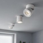 Biała lampa sufitowa Tubo z trzema spotami LED, każdy o mocy 12W i temperaturze barwowej 4000K. Ujęcie z góry pokazuje lampy zamontowane na suficie, w różnych pozycjach, z widocznymi zaokrąglonymi kloszami. Tło w jasnym kolorze.