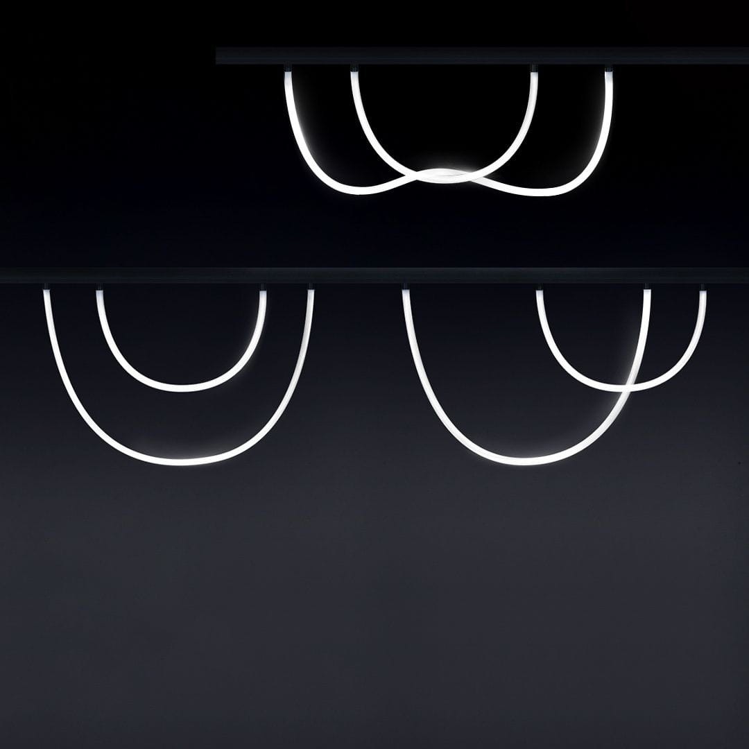 Wężyk LED 100 do szyny magnetycznej, z białym światłem o temperaturze 4000K. Ułożony w różne krzywe, z widoczną szczeliną na górze. Produkt zamontowany na ciemnym tle, ukazujący elastyczność i nowoczesny design.