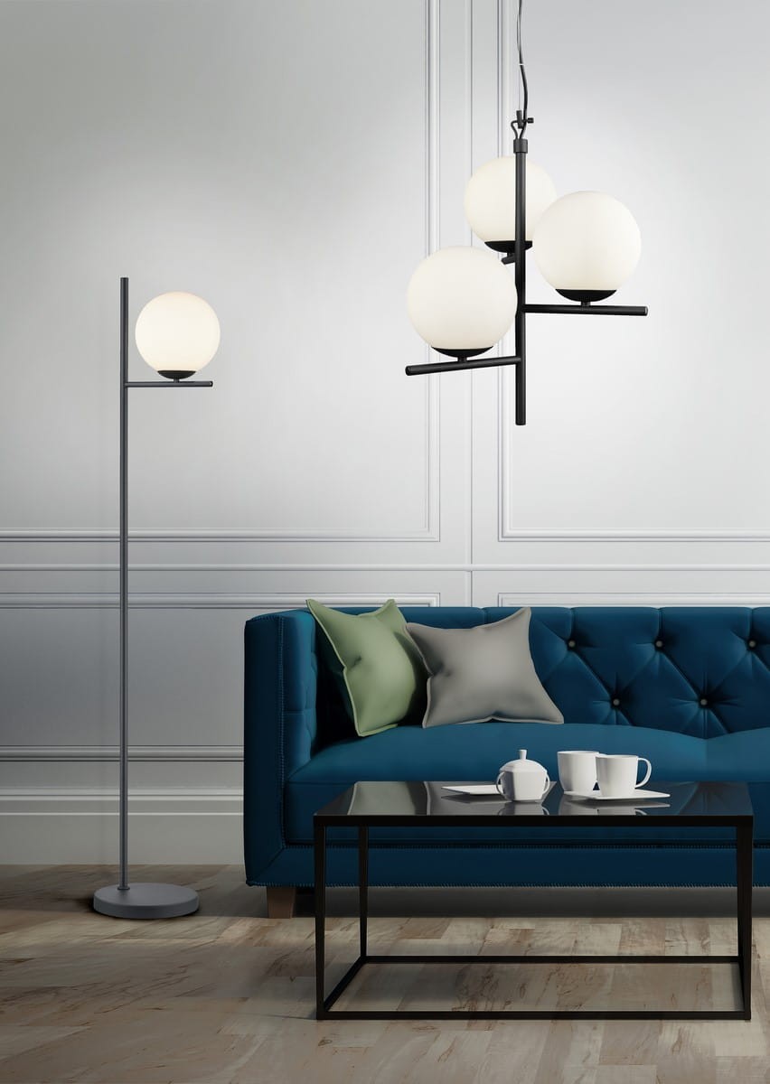 Czarna lampa wisząca Pure z trzema okrągłymi, matowymi kloszami, zawieszona na cienkim kabelku. Produkt umieszczony w nowoczesnym wnętrzu z niebieską kanapą i czarnym stołem, na którym znajdują się filiżanki.