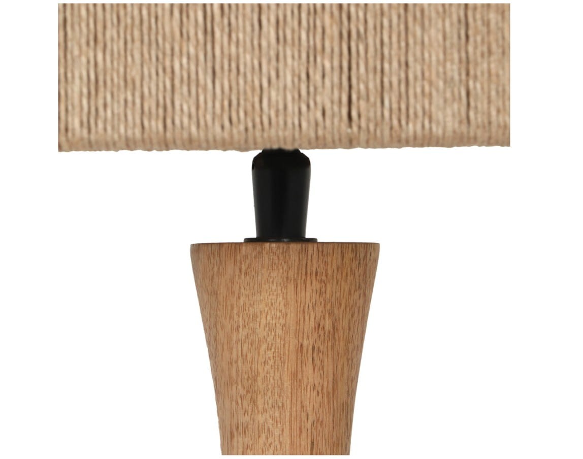 Lampa stojąca Toba z jasnego drewna, z podstawą w kształcie stożka i czarnym elementem mocującym. Klasyczny klosz z juty w naturalnym kolorze. Ujęcie w zbliżeniu na detal połączenia klosza z podstawą.