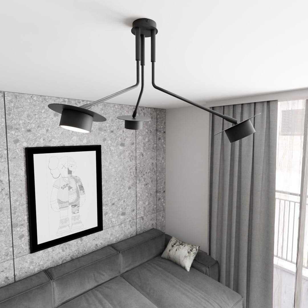 Czarna lampa sufitowa Mizu z trzema reflektorami GX53, umieszczona w nowoczesnym wnętrzu. Lampa ma minimalistyczny design z metalowymi ramionami, skierowanymi w różnych kierunkach, w tle widoczna szara ściana i kanapa z poduszką.