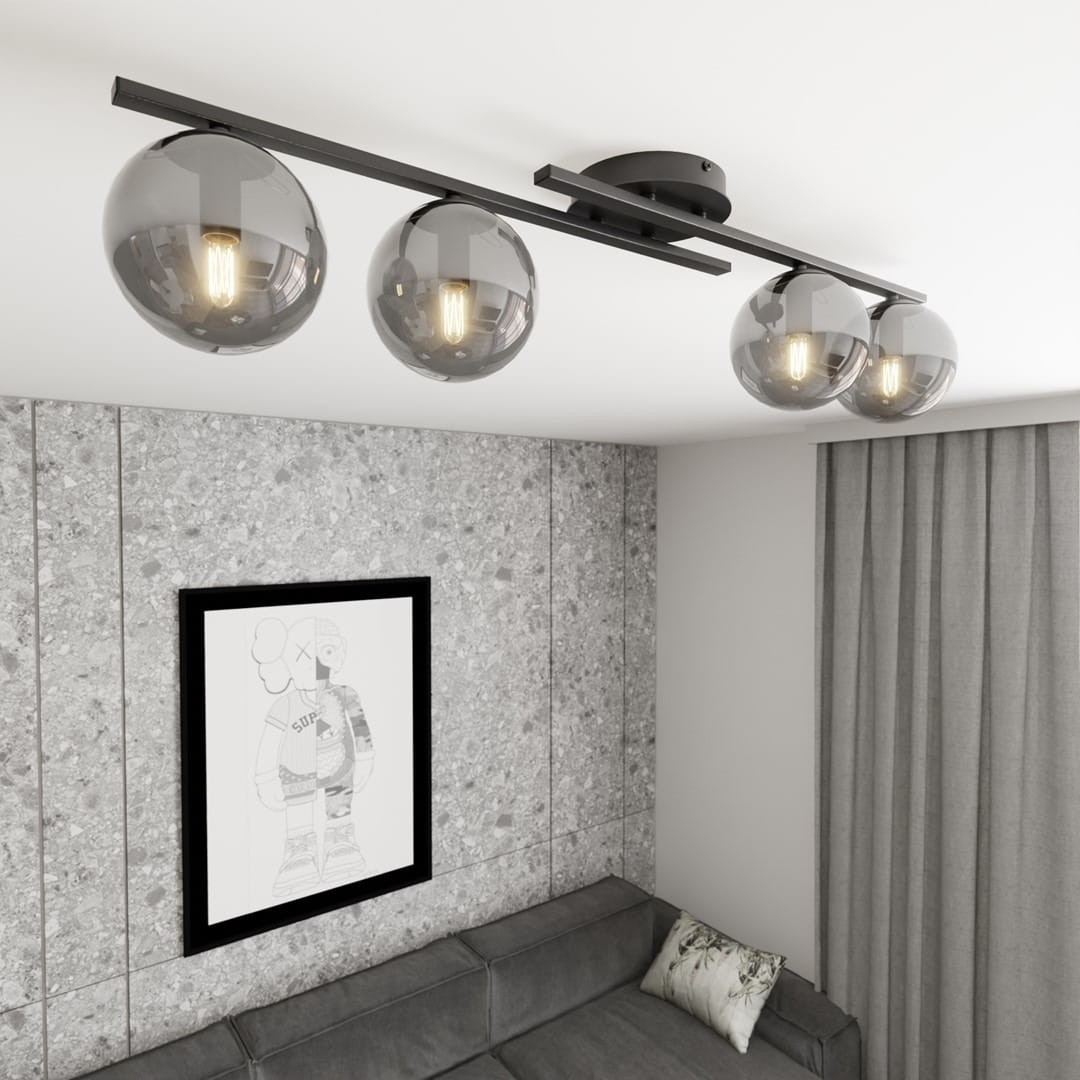 Czarna lampa sufitowa Kairo z czterema kloszami w kolorze grafitowym, zamontowana na prostokątnej listwie. Klosze mają okrągły kształt z przezroczystego szkła, odsłaniają żarówki E14, umieszczona w nowoczesnym wnętrzu z szarymi ścianami i sofą.
