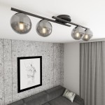 Czarna lampa sufitowa Kairo z czterema kloszami w kolorze grafitowym, zamontowana na prostokątnej listwie. Klosze mają okrągły kształt z przezroczystego szkła, odsłaniają żarówki E14, umieszczona w nowoczesnym wnętrzu z szarymi ścianami i sofą.