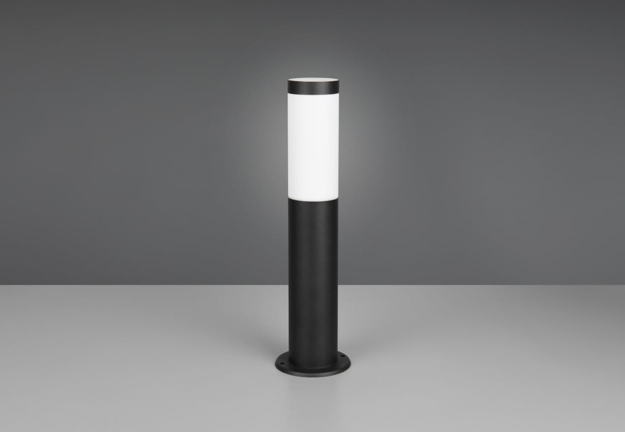 Lampa stojąca ogrodowa Trioto H45, czarna, z cylindrycznym kloszem z białego tworzywa. Ujęcie frontalne, produkt stoi na płaskiej powierzchni. Posiada miejsce na żarówkę E27. Stabilna podstawa z otworami montażowymi.