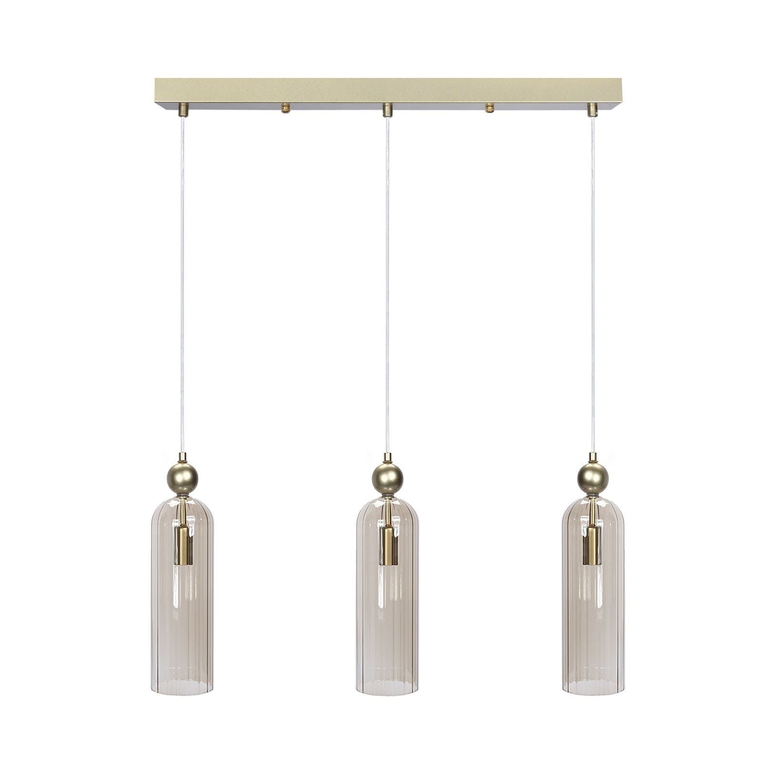 Lampa wisząca Regina z trzema kloszami E14 w kolorze złotym. Klosze mają cylindryczny kształt, wykonane z przezroczystego szkła z pionowymi żłobieniami. Lampa zawieszona na białych linkach, montowana na prostokątnej podstawie.