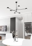 Lampa sufitowa Natsu w kolorze czarnym z sześcioma źródłami światła GX53, umieszczona na długim ramieniu w kształcie rozgałęzienia. Ujęcie z dołu, pokazujące nowoczesny design w minimalistycznym wnętrzu z białym stołem i szarym dywanem.